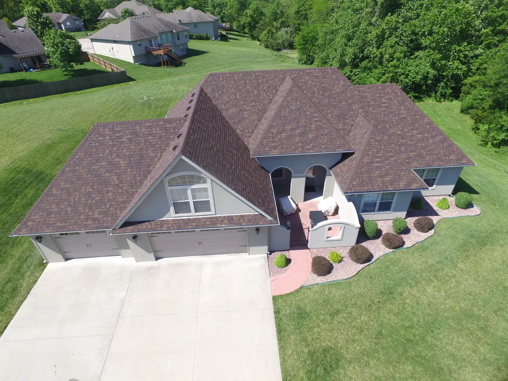 Roof repair work on damaged shingles near a chimney