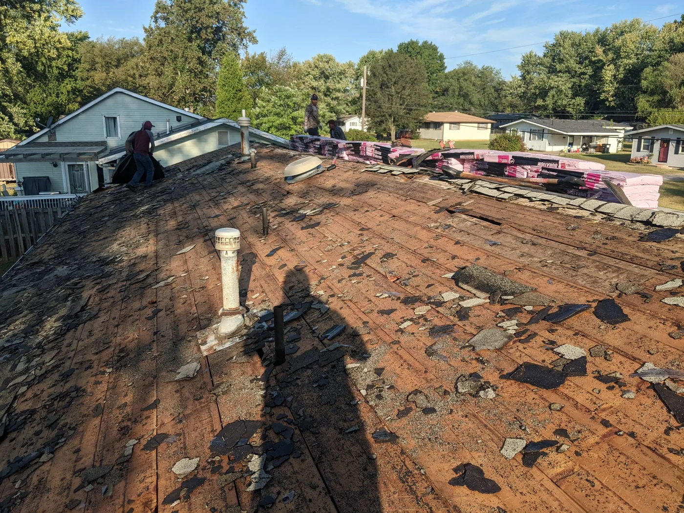 SRA roofing crew removing old shingles during a residential tear-off