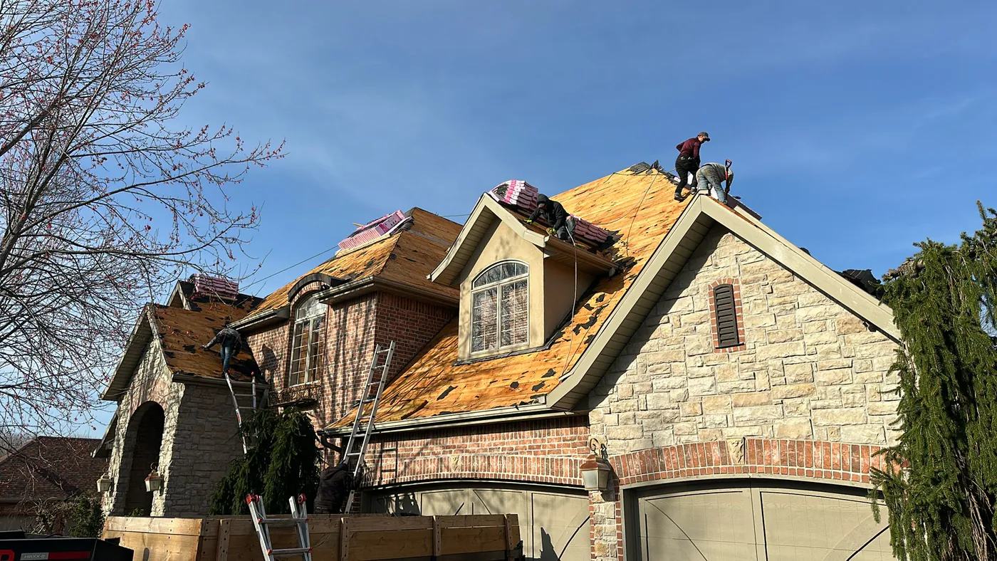 Roofing crew completing a full tear-off on a residential roof